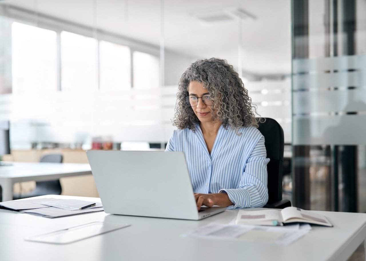 Older woman working at a computer.