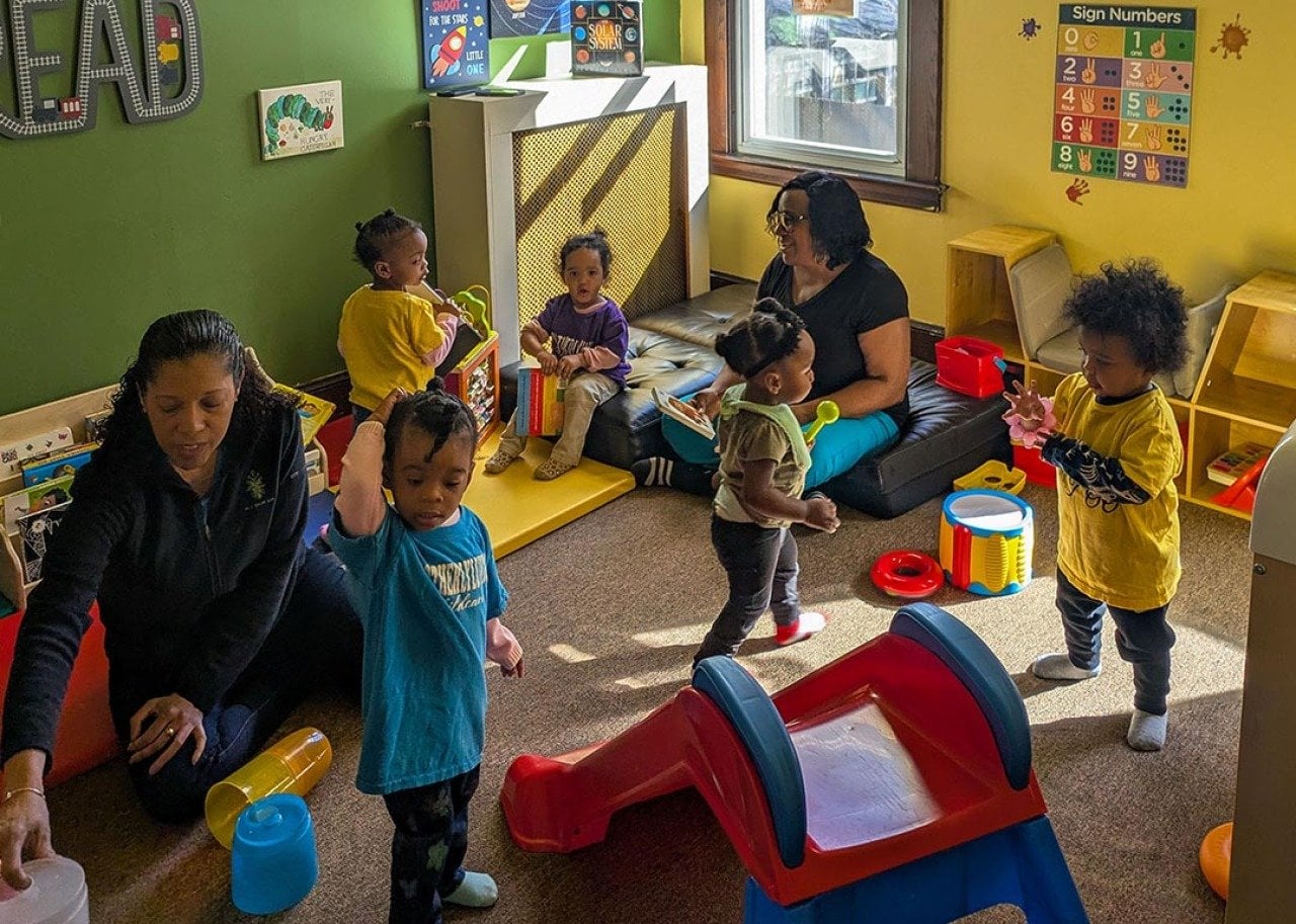 Toddlers play in a colorful room at Sandra Dill’s family child care.