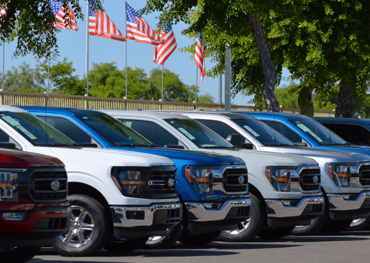 A row of Ford F-150 trucks for sale at a car dealership