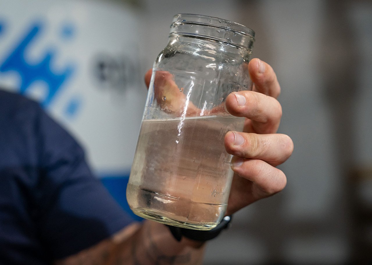 The director of water re-use operations for startup Epic Cleantec holds up a sample of treated water.