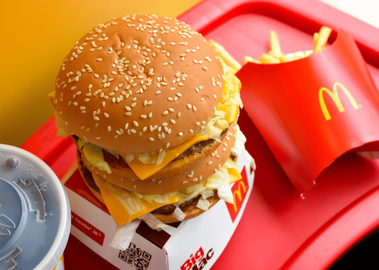 A McDonald's meal consisting of teo Big Macs, a side of fries and a soda on a red tray