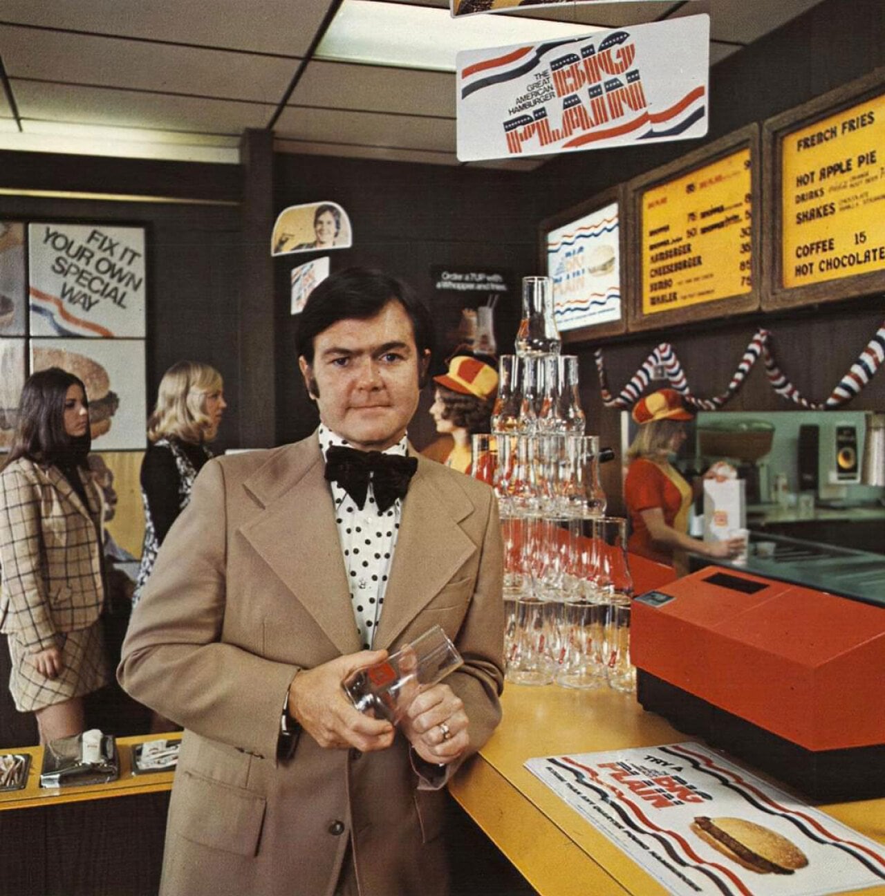 A man in a suit holding a glass inside of a Burger King