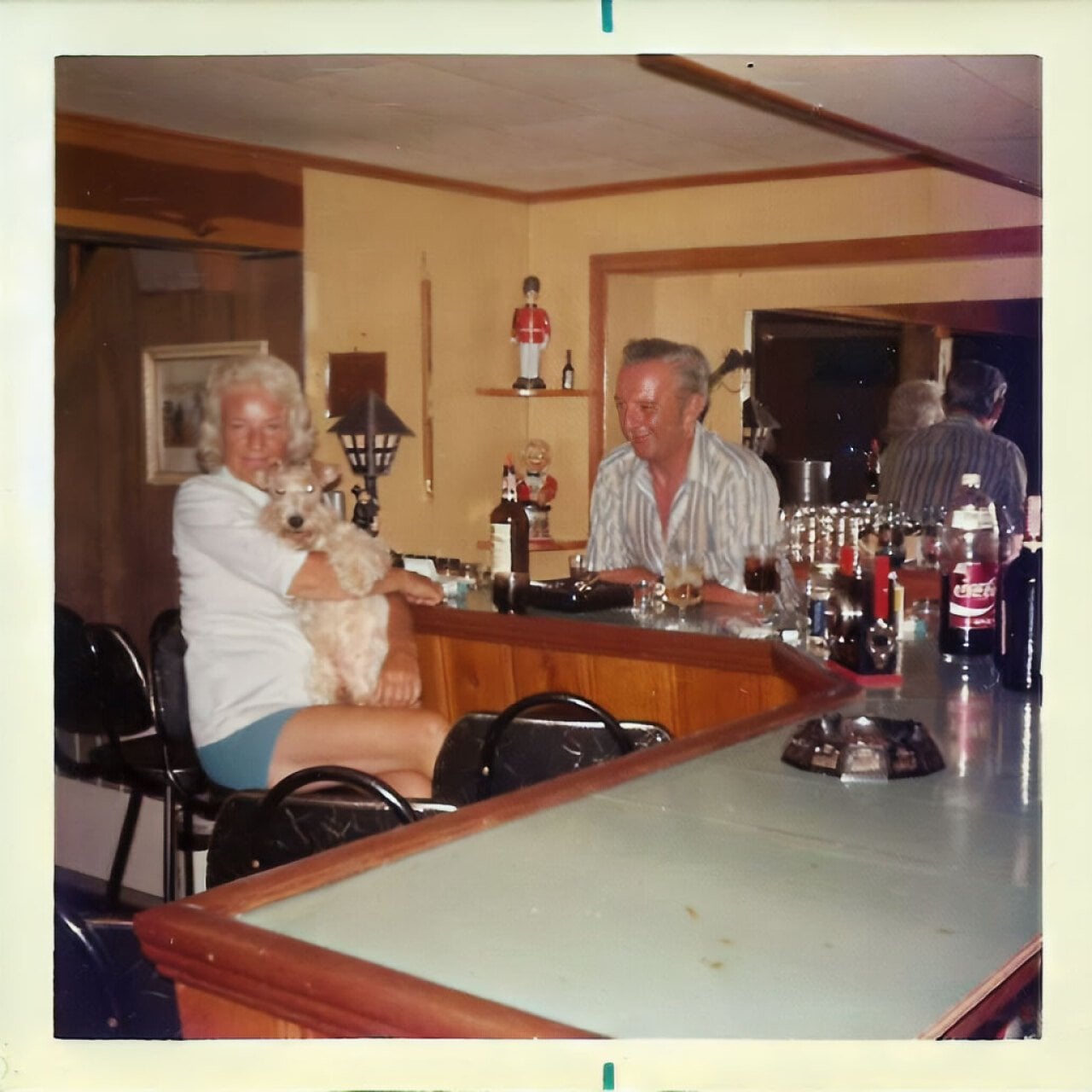 An older couple sitting around in their basement bar