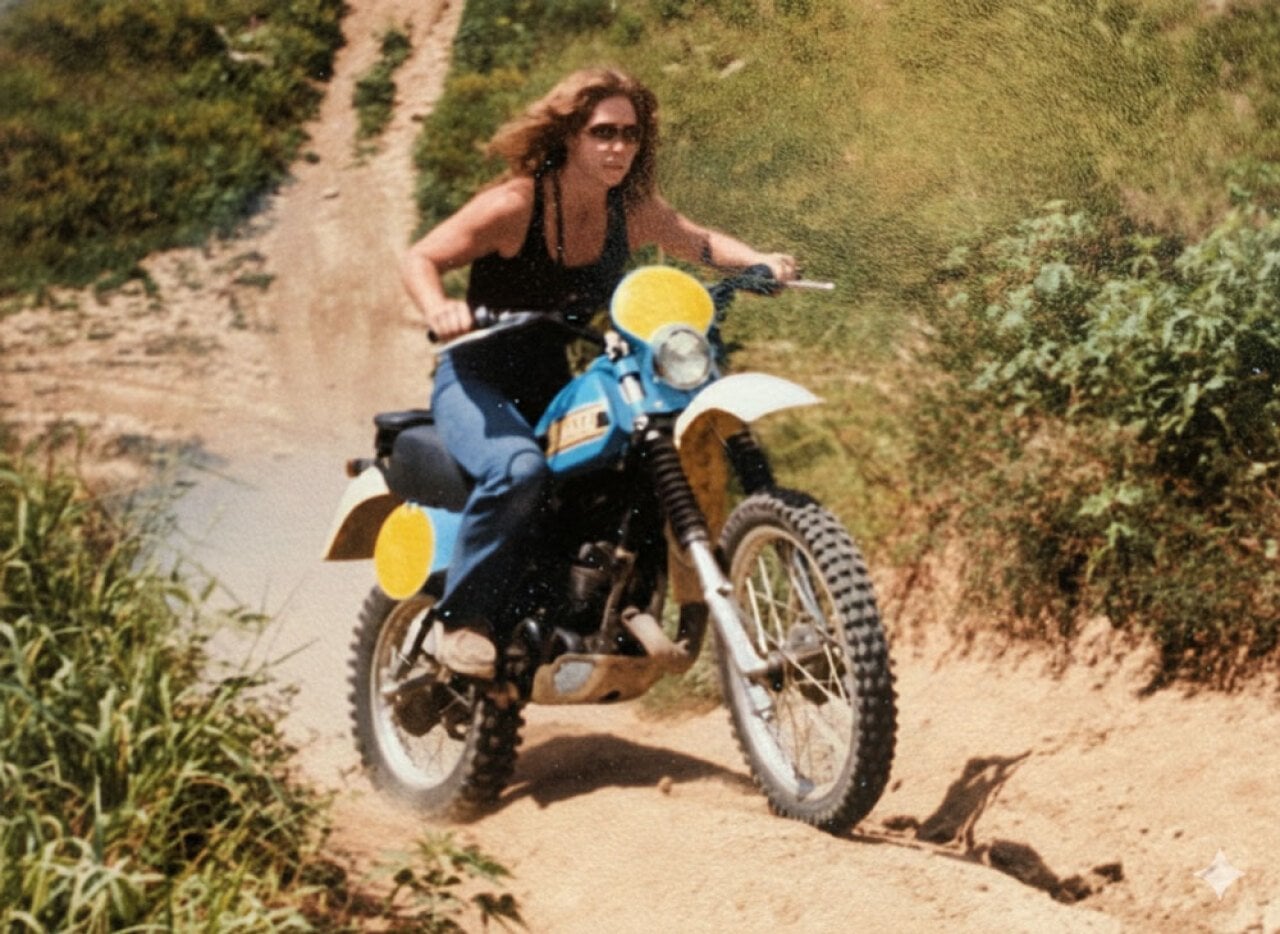A woman riding up a steep hill on a dirt bike