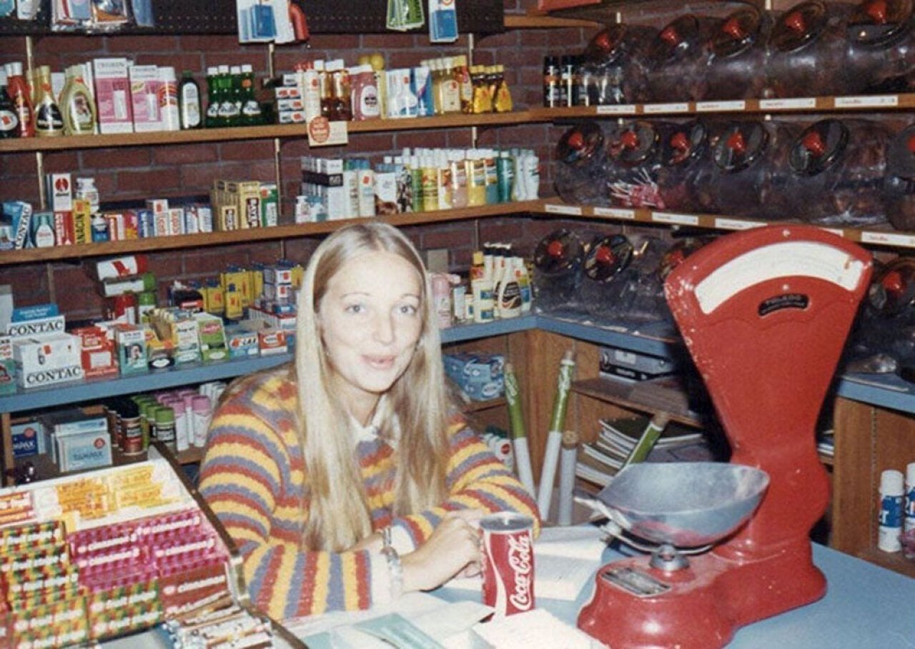 Woman wearing a striped swearing sitting behind the counter at a grocery store