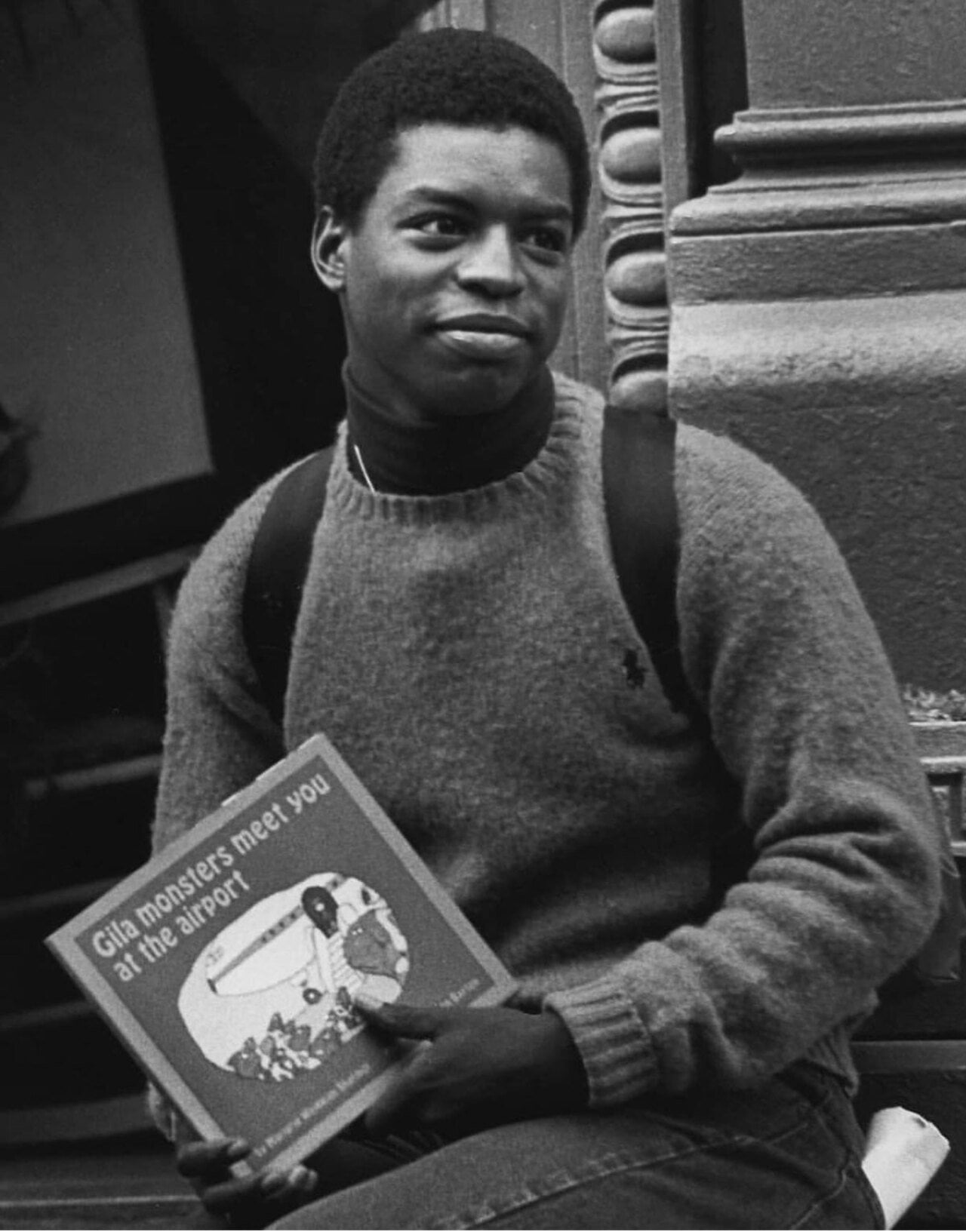 Black and white photo of LaVar Burton holding a book titled 