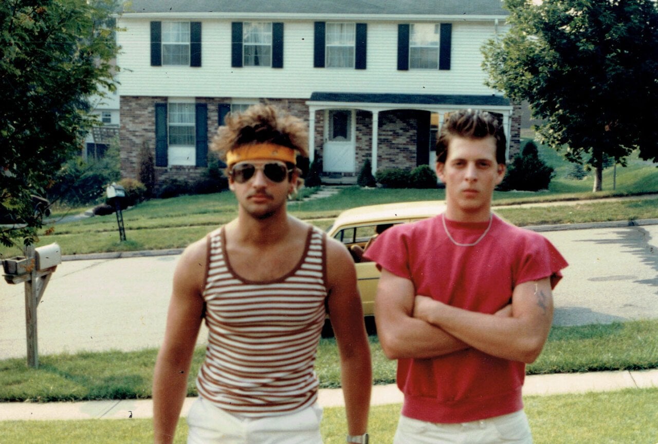 Two guys standing in a front yard dressed for a concert