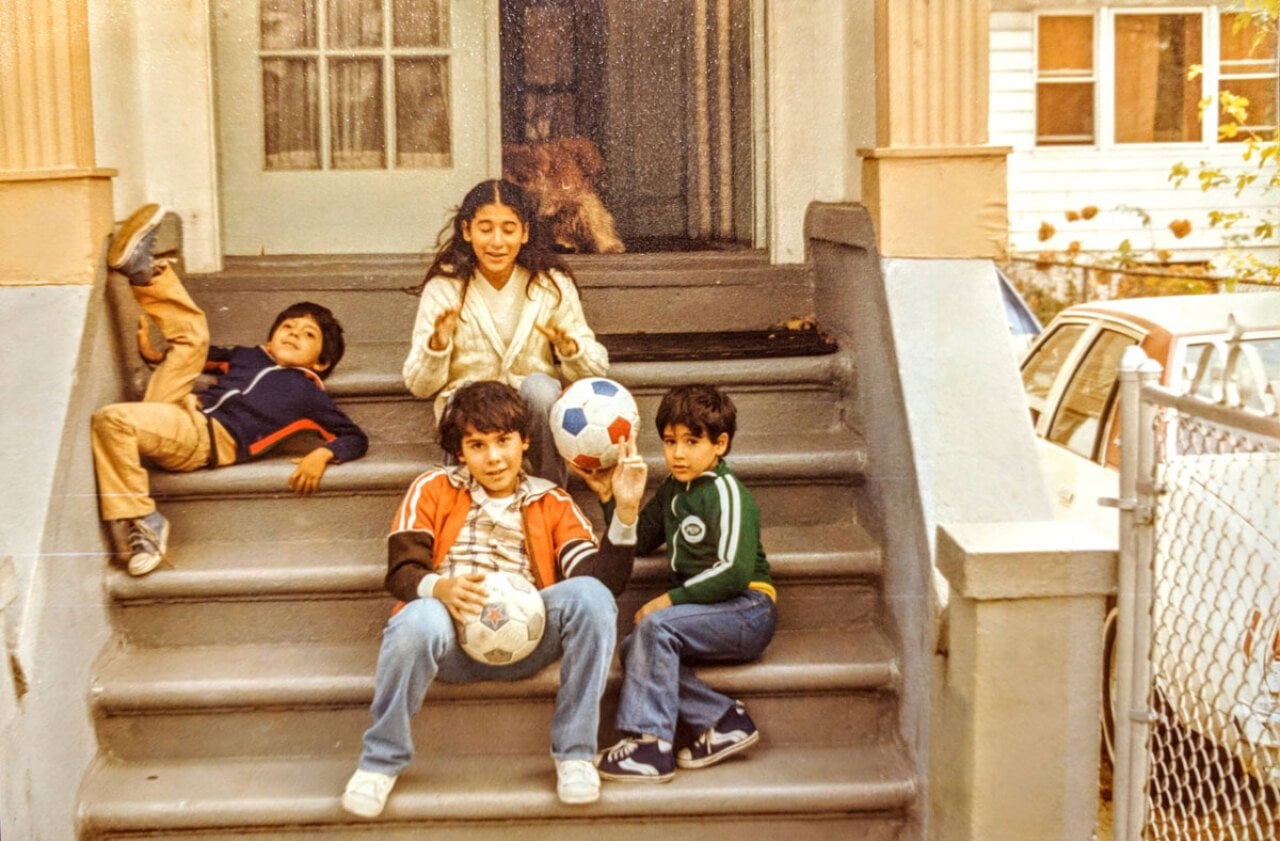 Kids hanging out on a stoop with soccer balls