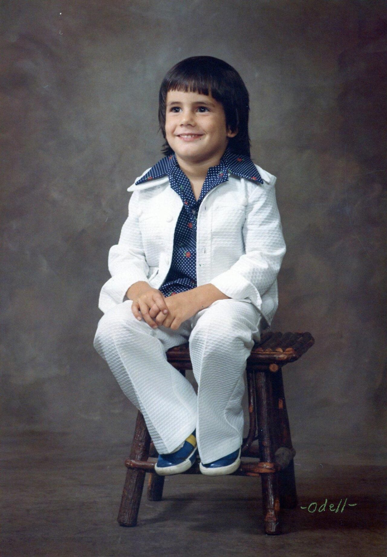 A kid in a very 1970s white suit for a school photo