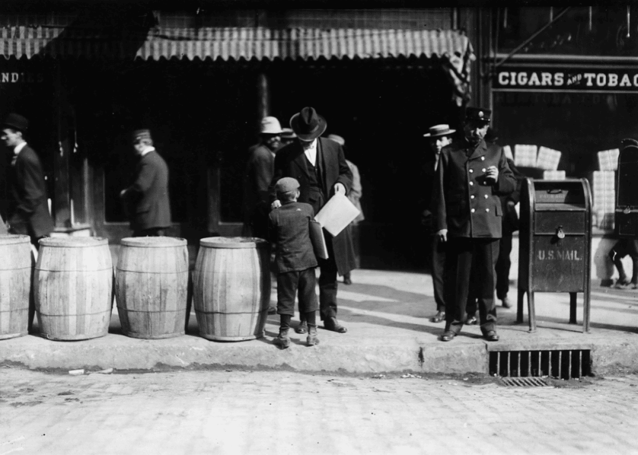 A boy sells a newspaper to a man on city street