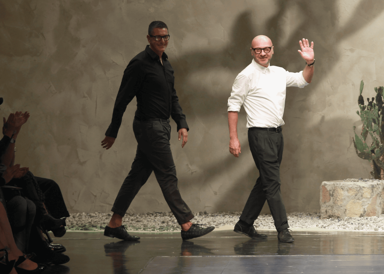 Domenico Dolce Domenico Dolce and Stefano Gabbana wave from runway at fashion show.