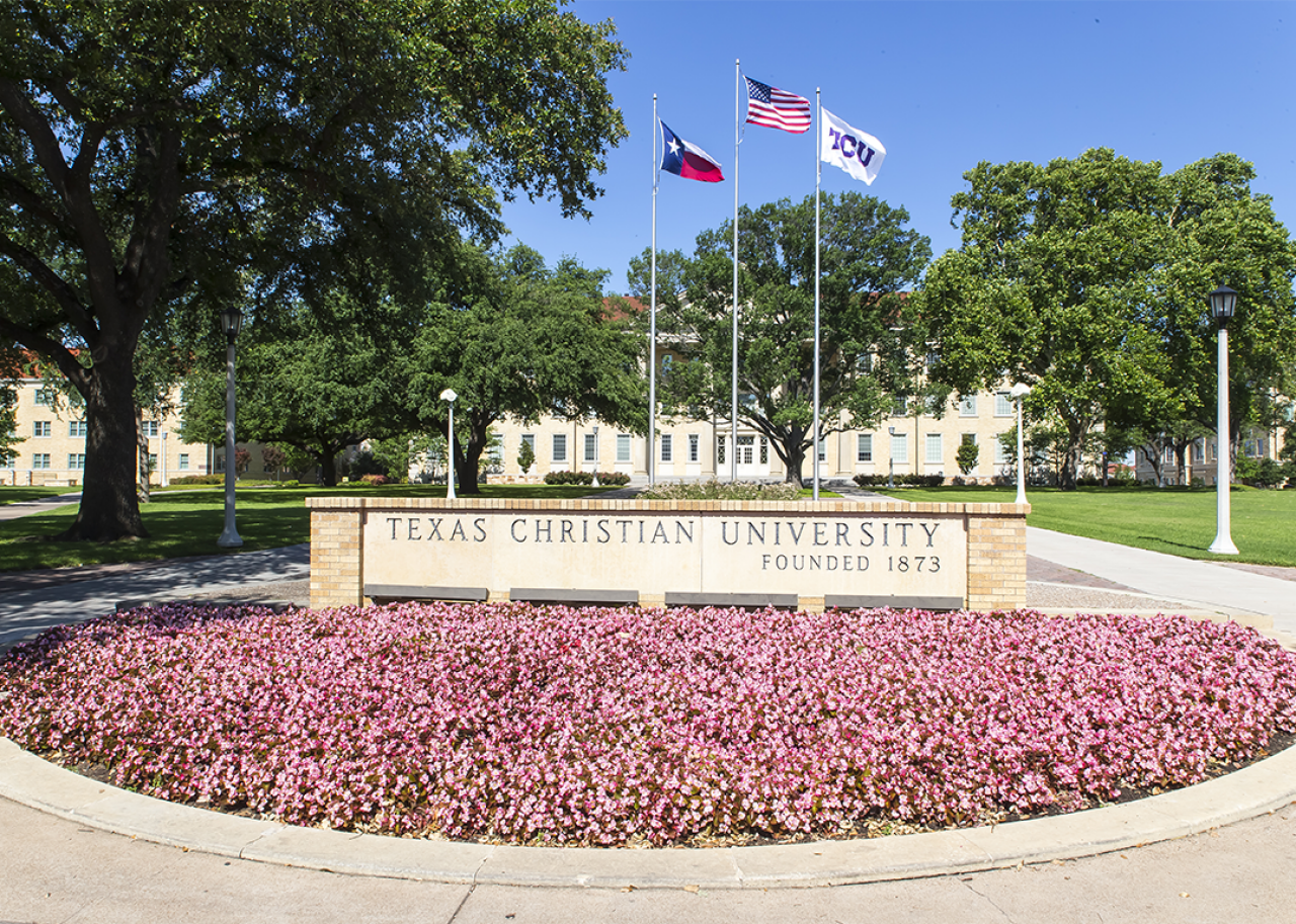 #27. Texas Christian University Campus sign with flags in springtime.