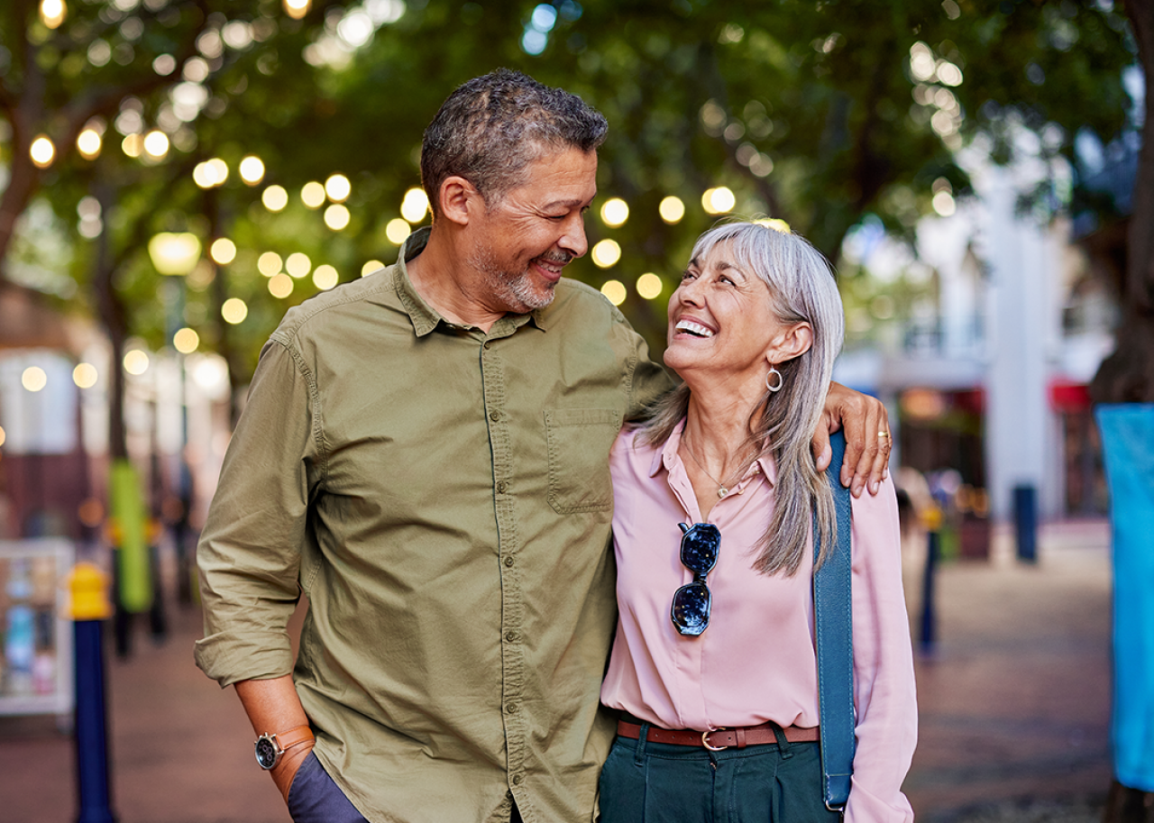 Cheerful couple walking on pedestrian street.