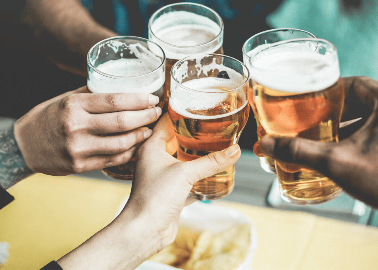 Friends raise a toast with pints of beer.