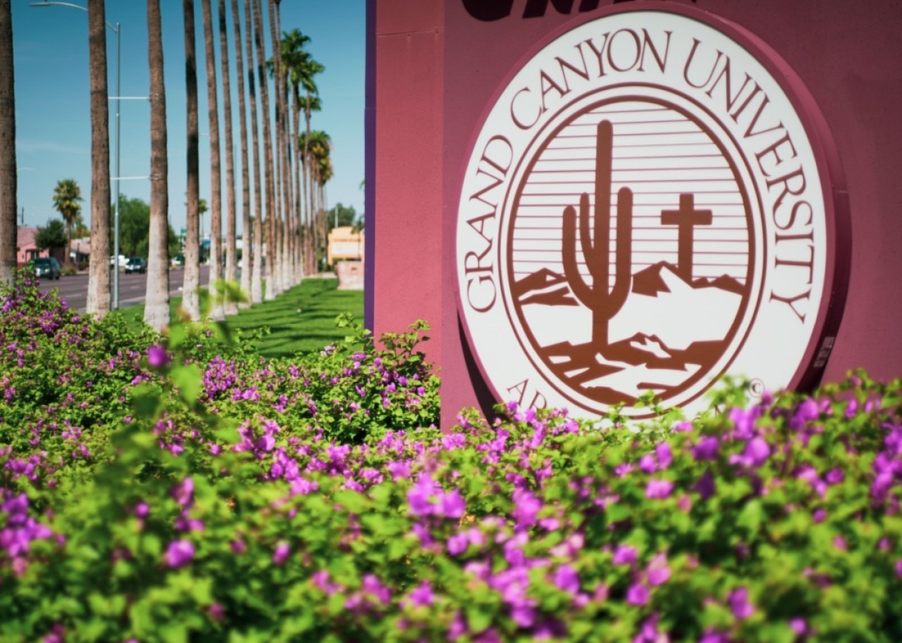 The Grand Canyon University sign with palm trees in the background.