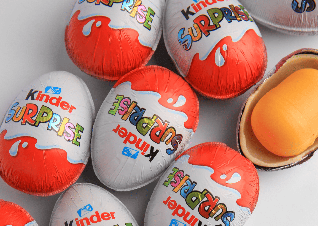 A collection of Kinder Eggs resting on a white surface.