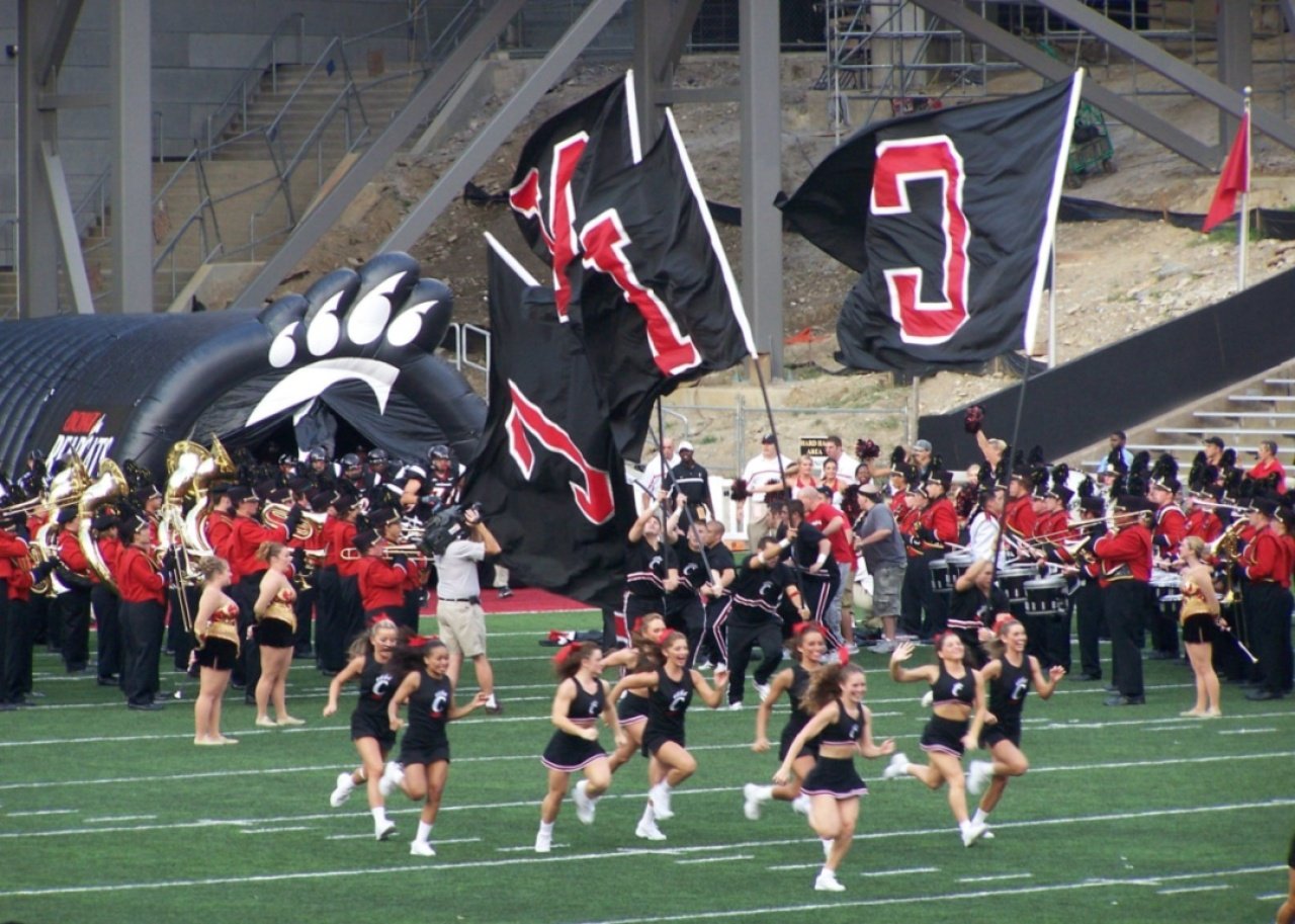 #27. University of Cincinnati University of Cincinnati cheerleaders running on the field.