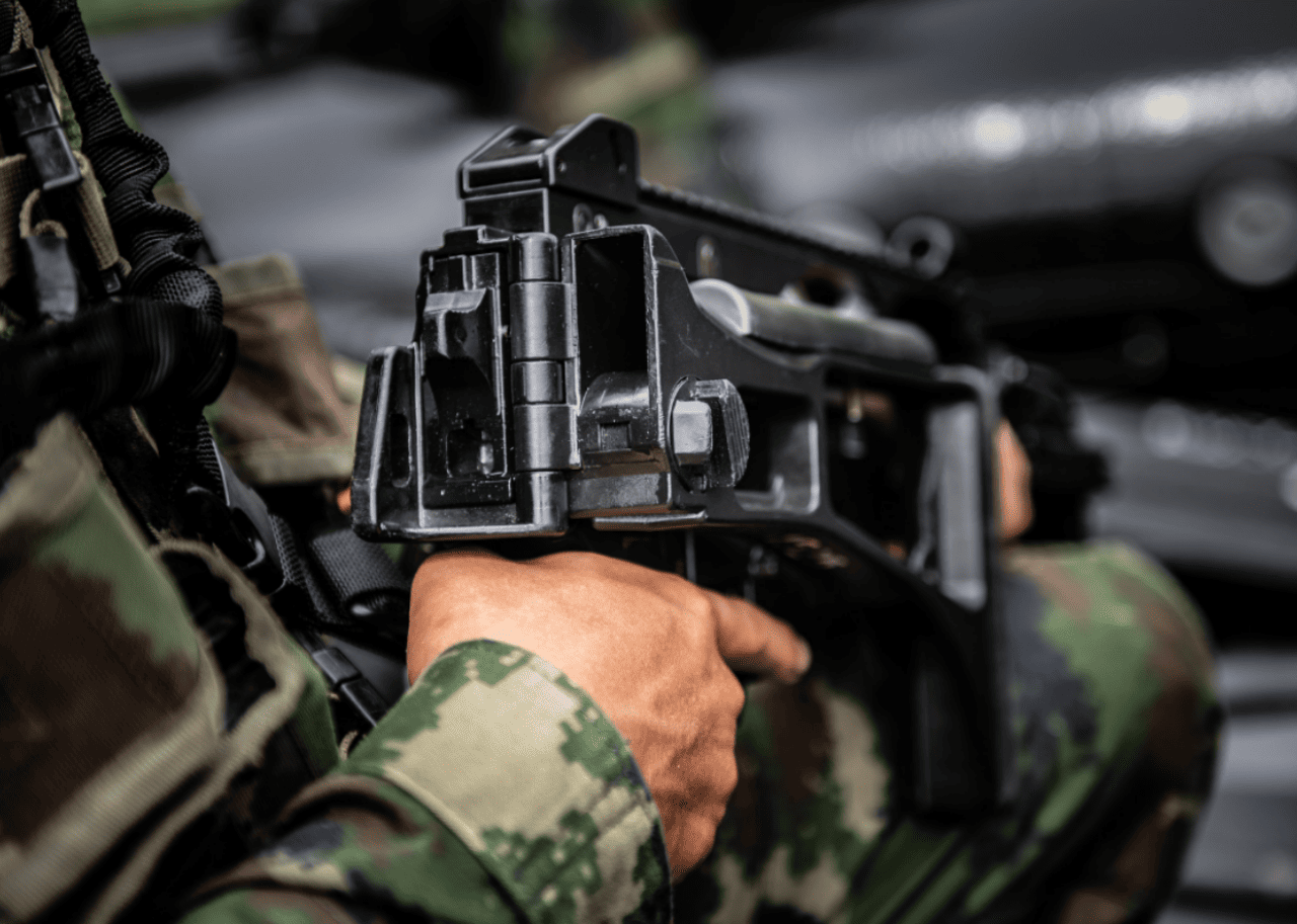 A soldier holding a large black gun.