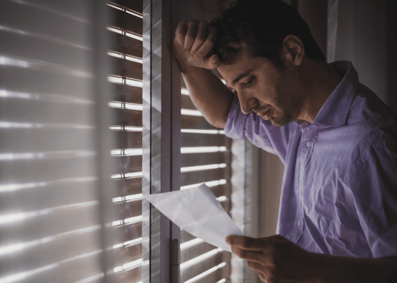 A sad man reading a letter.