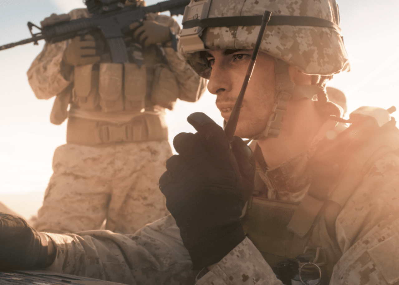 A soldier talking on a walkie talkie.