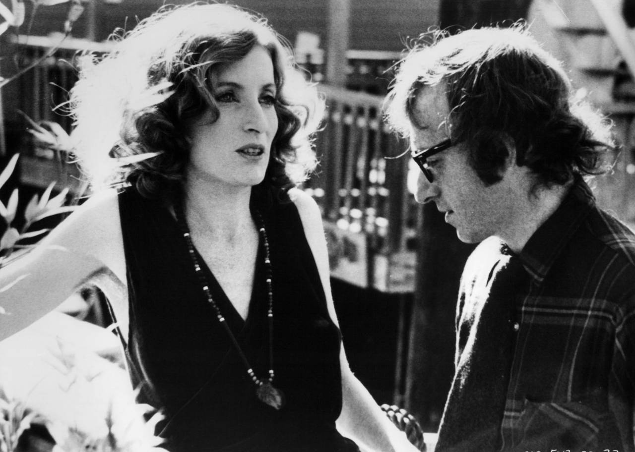 A black and white image of a man and woman talking.