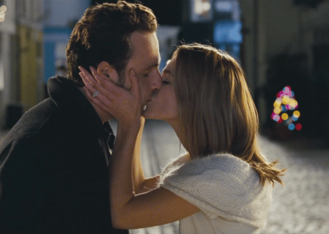 A man and woman kissing in the street.