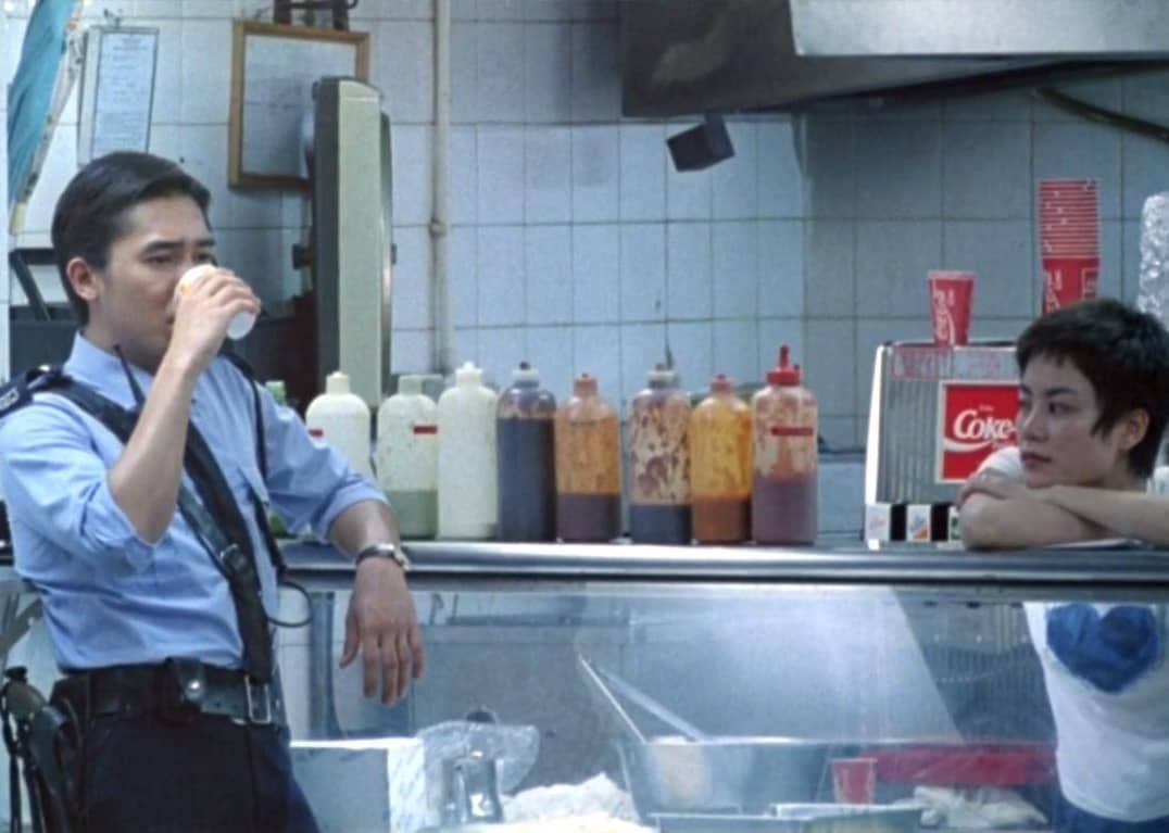 An officer stands next to an food business.