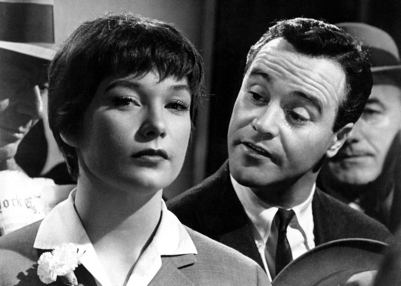 A woman looks unconvinced, as a man talks behind her.