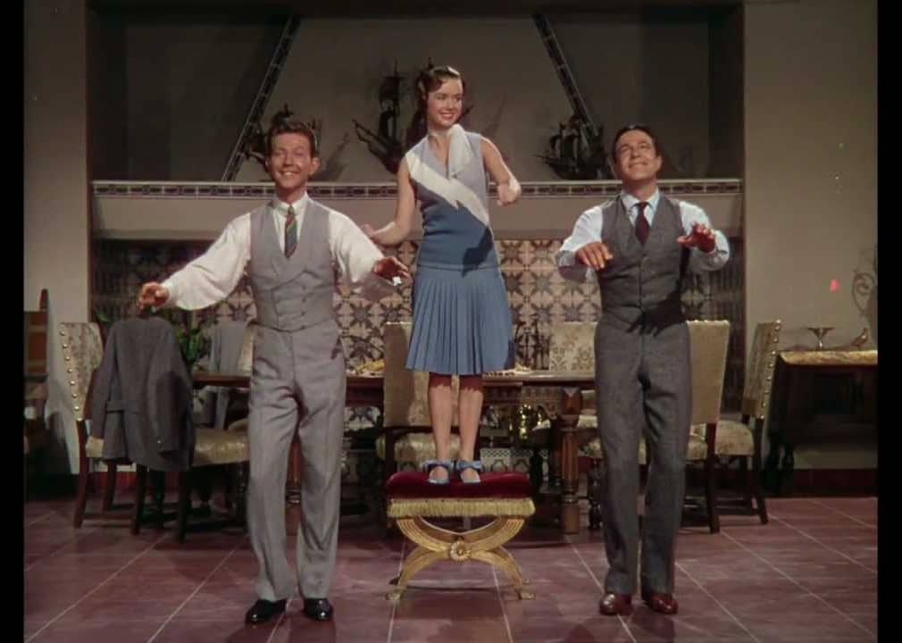 Two men and a woman dance.