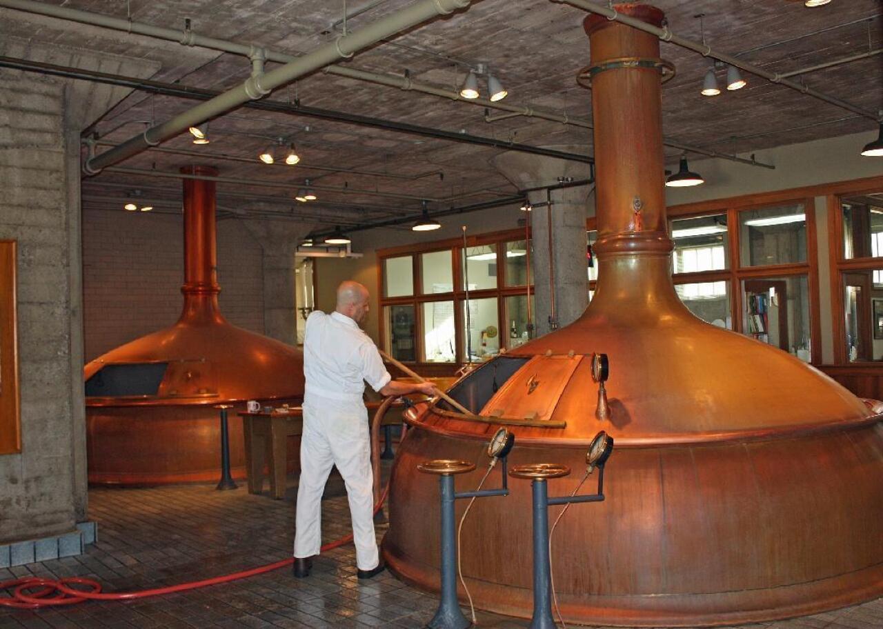 A brewer works at a mash tun at Anchor Brewing Company.