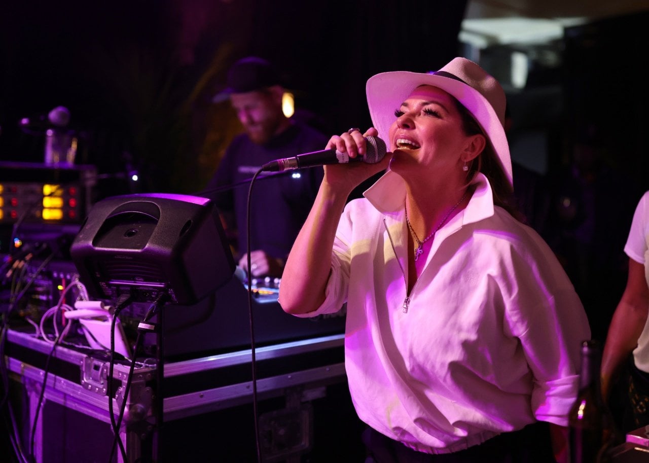 Shania Twain performs in a white panama hat and collared top.