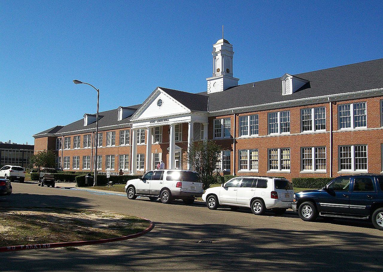 A long brick hall with a clocktower on top.