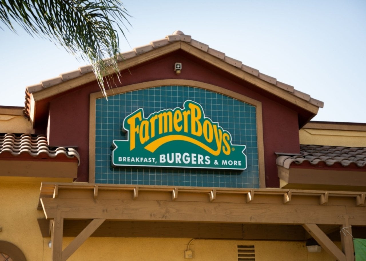 A green and yellow sign on a Farmer Boys restaurant.