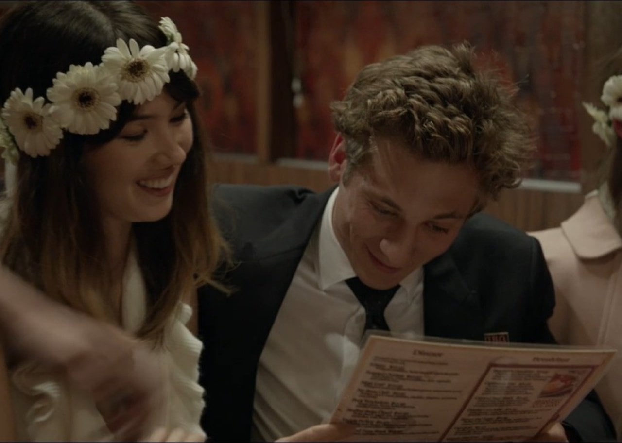 A man in a suit with a woman wearing a flower crown.
