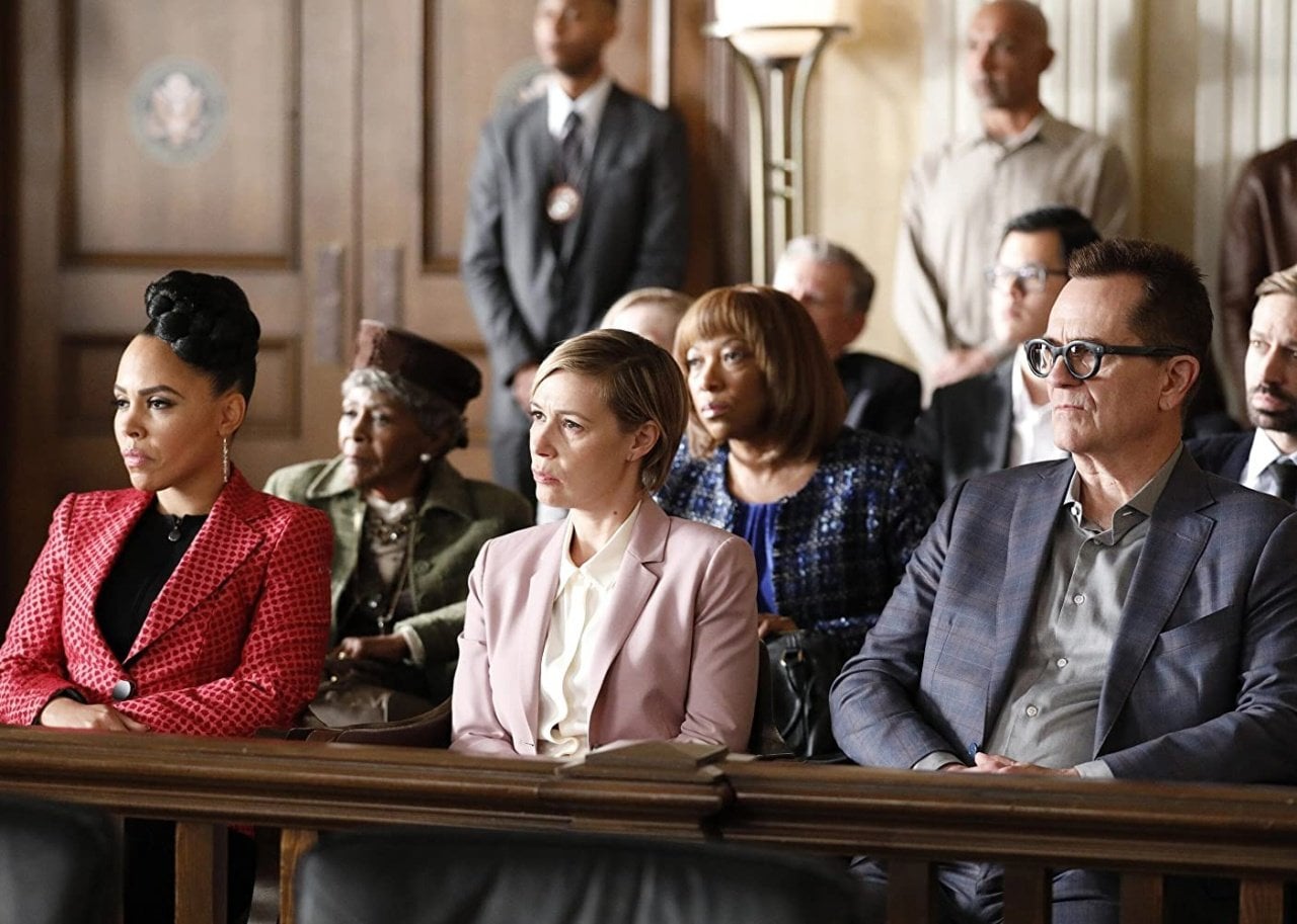 People sit in court benches listening intently.