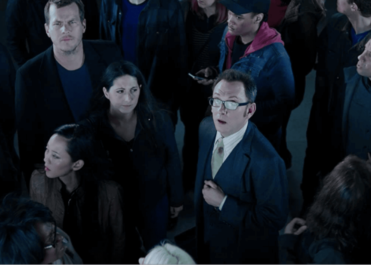 A man looking up in a crowd of people.