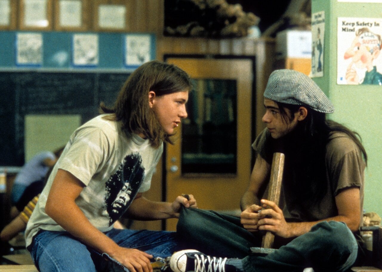 Rory Cochrane holding a bong, talking to another student, in a scene from Dazed and Confused.