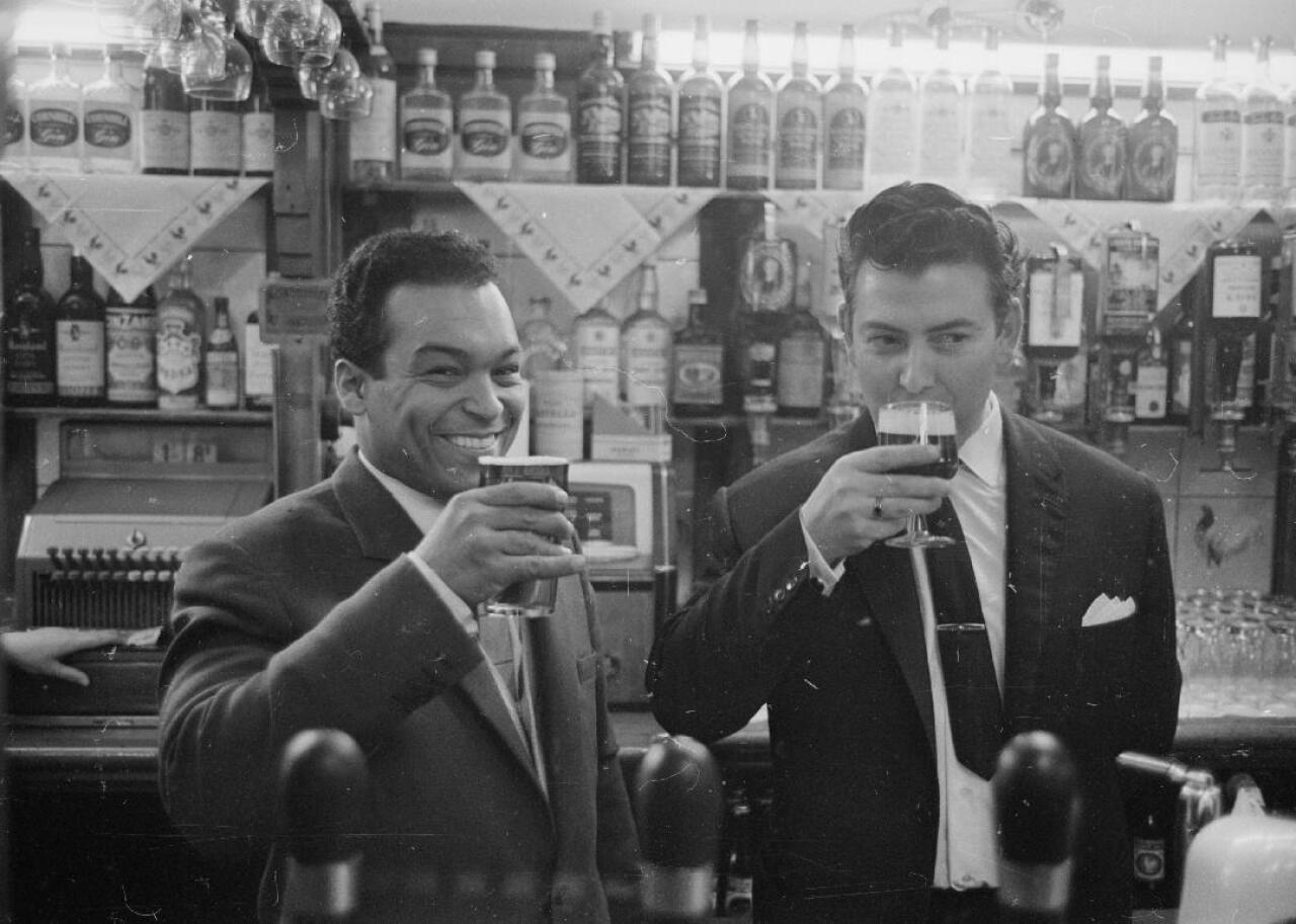 Two men enjoying beers in a bar.