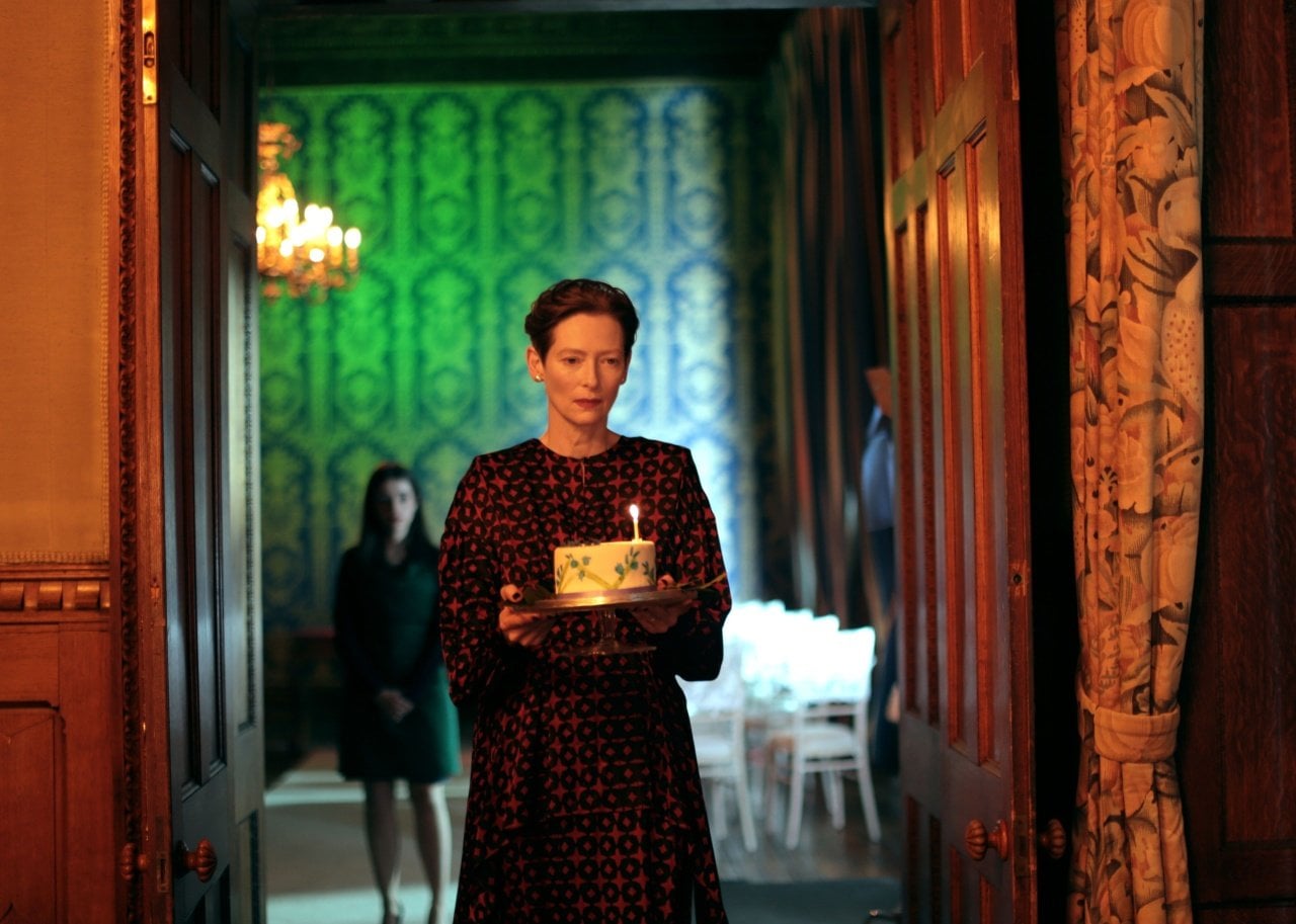 Tilda Swinton carrying a birthday cake.