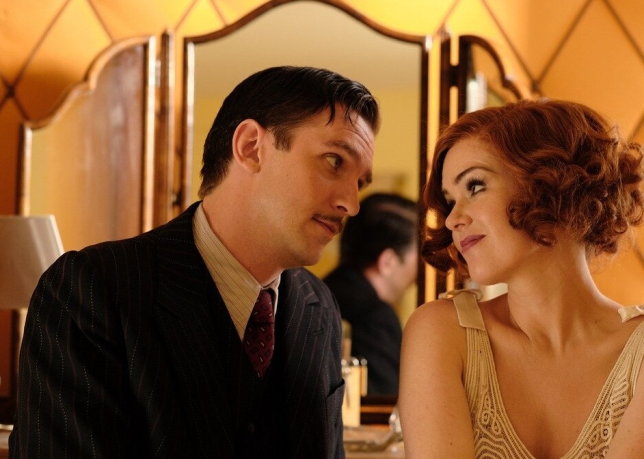 Isla Fisher and Dan Stevens looking longingly at one another.