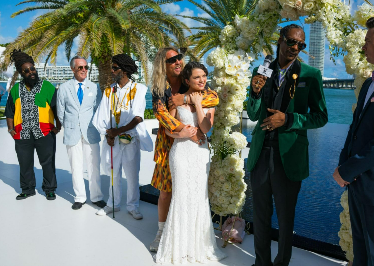 Matthew McConaughey hugging Stefania LaVie Owen in a wedding dress, while standing next to Snoop Dogg, Jimmy Buffett, and Joshua Ritter, along with two other men, in The Beach Bum.