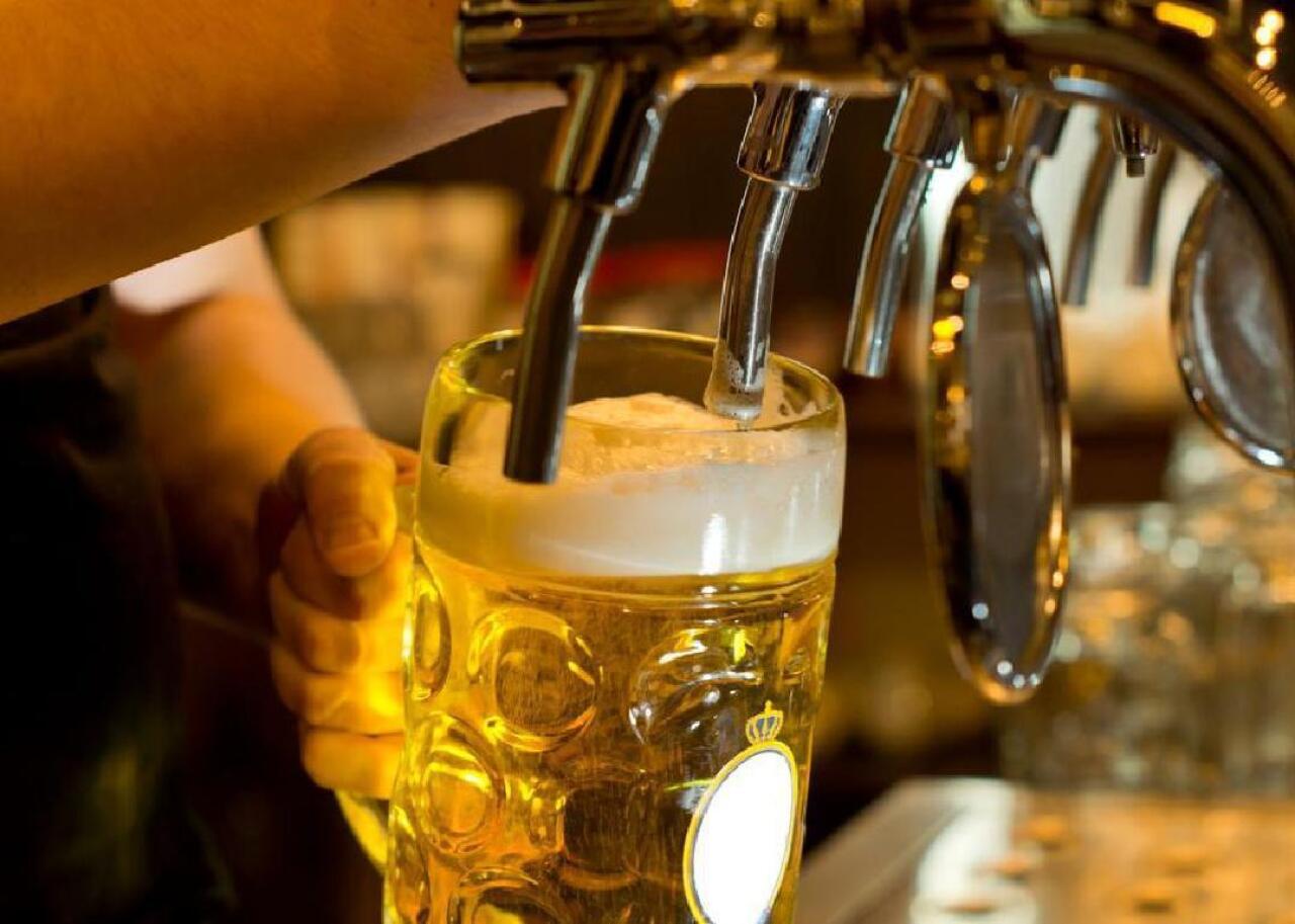 Beer flows from a tap into a stein.