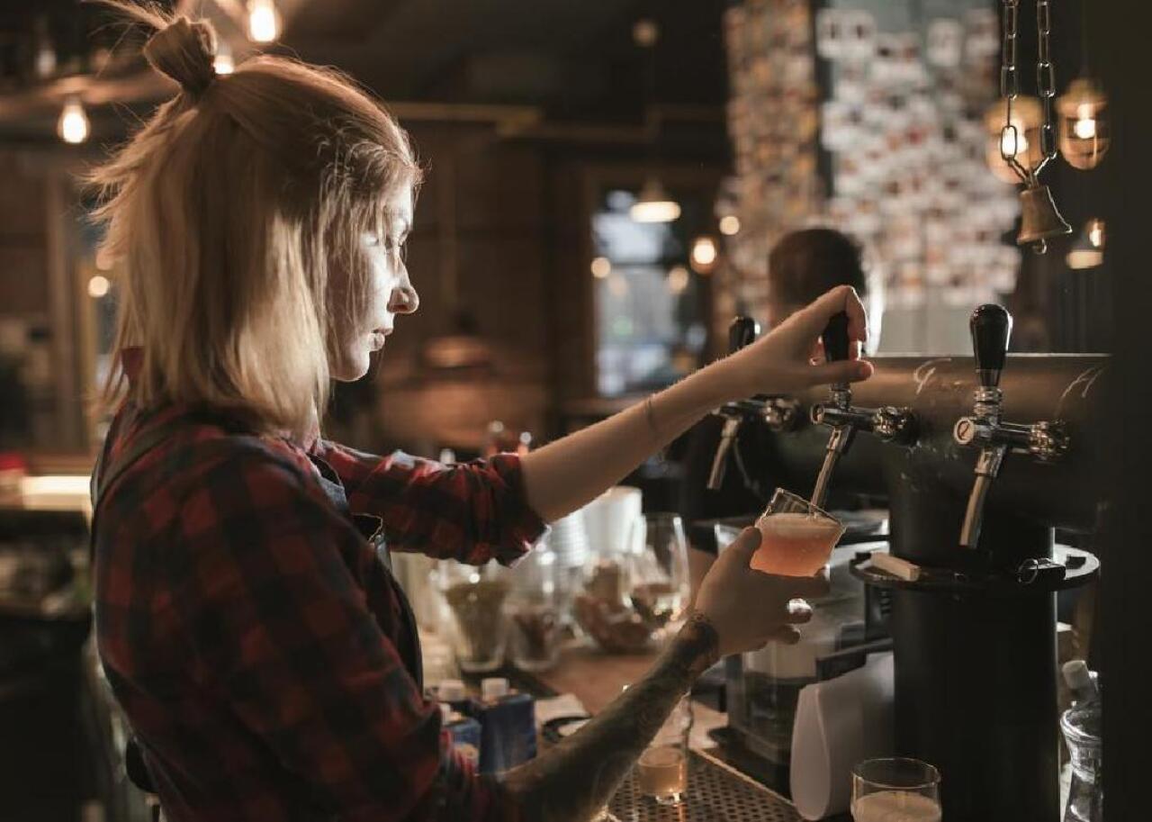 A beertender fills up a glass at a pub.