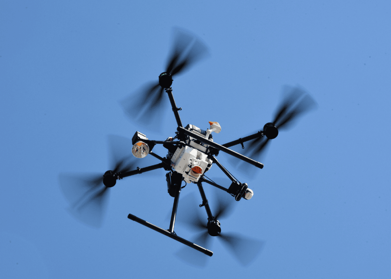 A drone in mid-flight making a delivery.