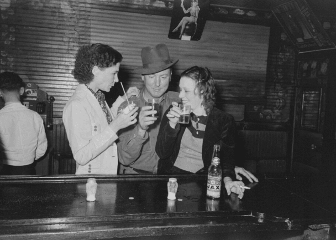 Some friends drink beverages at a bar. 