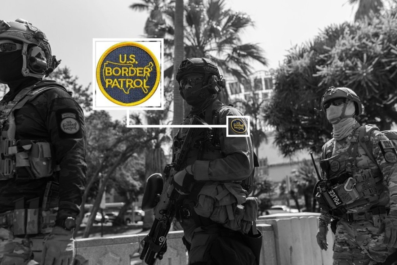 Black and white image of three federal agents, faces covered with balaclavas and sunglasses, at MacArthur Park in Los Angeles, with an inset enlargement detail of the U.S. Border Patrol patch, in color, that is visible on one agent's sleeve.