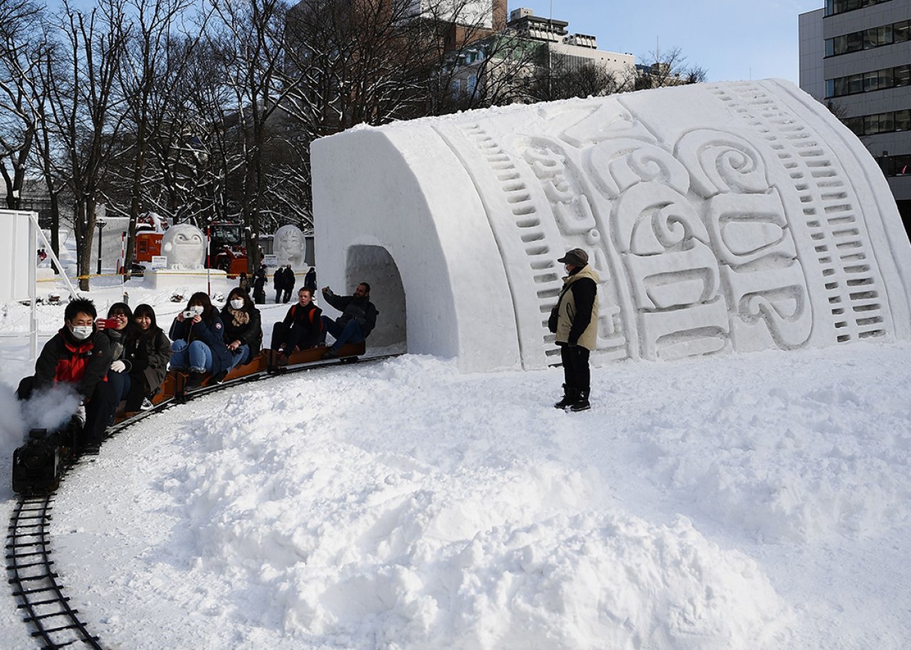 People ride through the Cup Noodles and Rui Hachimura's snow tunnel during the 2020 Sapporo Snow Festival in Hokkaido, Japan.
