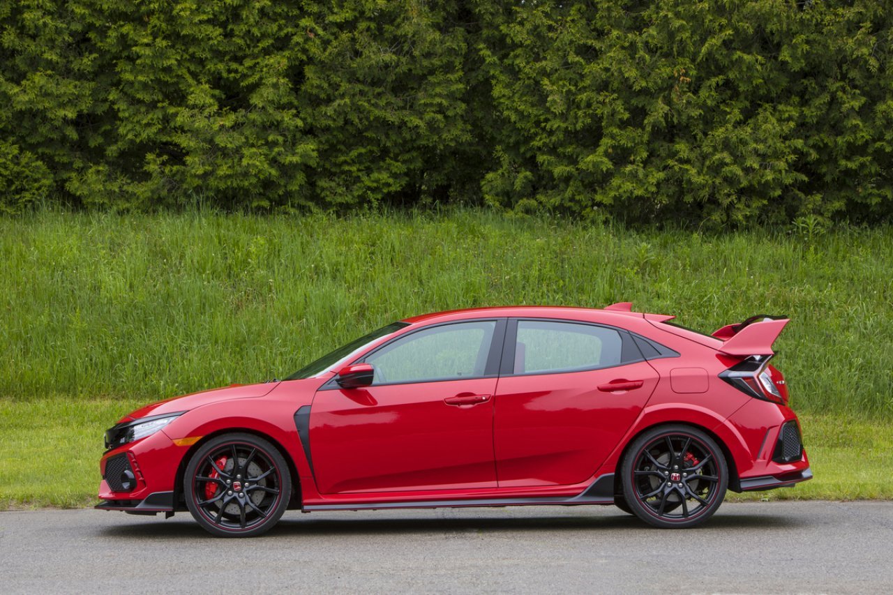 Red Civic Type R in front of a field of grass. 