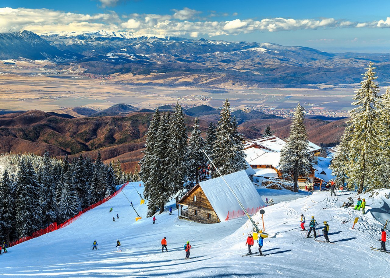 A scenic view of the wooden chalets and spectacular ski slopes in the Carpathians, Poiana Brașov Ski Resort in Romania.