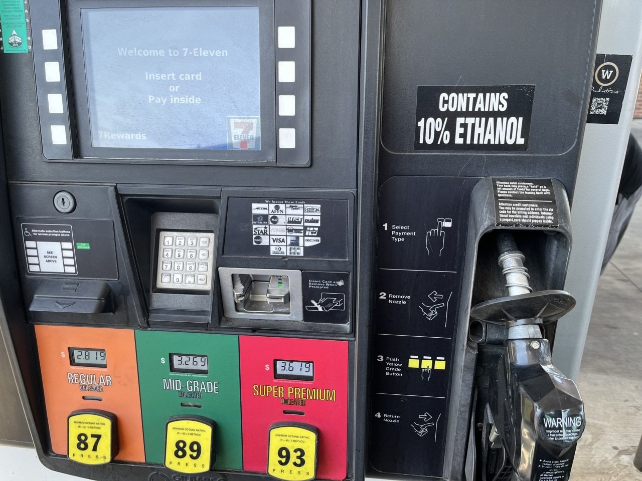 Gas pump photo at 7-eleven showing three grades of gas, a pump, with a sticker that says 